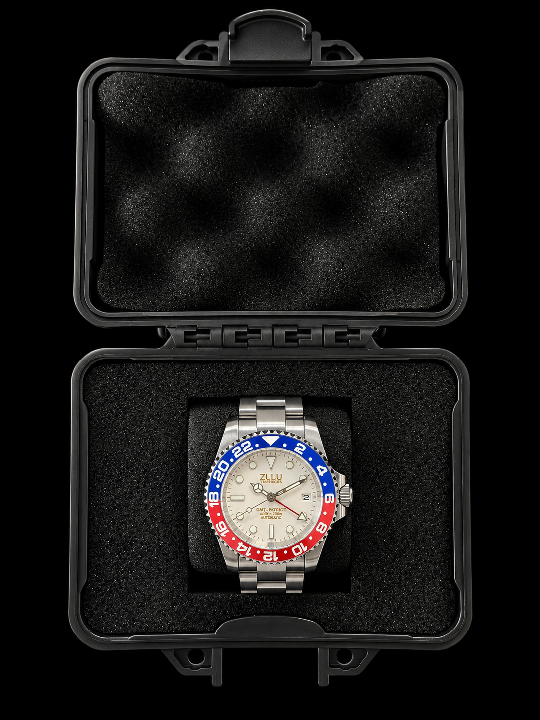 A stainless steel wristwatch with a silver-tone metal bracelet and a distinctive red, white, and blue bezel sits inside an open black protective case with black foam padding, set against a solid black background.